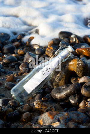 Un message d'aide dans une bouteille échouée sur un rivage Banque D'Images