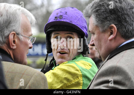 Jockey Tony McCoy avec l'entraîneur Paul Nicholls (à droite) et le propriétaire Clive Smith (à gauche) après la victoire sur Maître dans le Victor Chandler Steeple Chase Banque D'Images