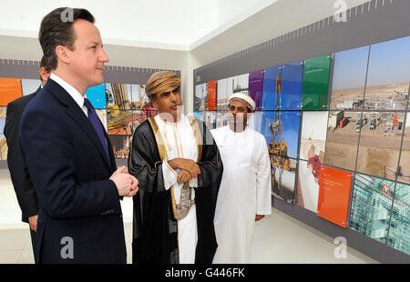 Le Premier ministre britannique David Cameron et le ministre omanais du pétrole et du gaz Dr Mohammed bin Hamed Al Romhi (au centre) voient une exposition avant un événement à BP à Muscat, Oman, pour l'inauguration officielle de l'installation d'essai de puits prolongé de BP Oman. Banque D'Images