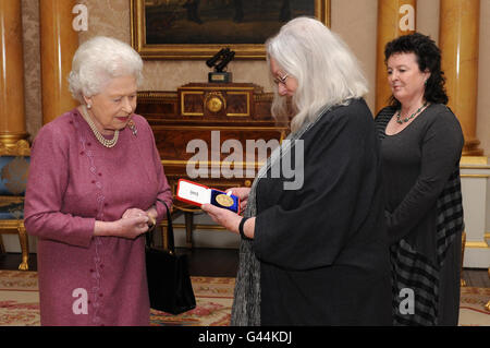 La reine Elizabeth II de Grande-Bretagne présente la poète Gillian Clarke (au centre) avec sa médaille d'or pour la poésie surveillée par la poète lauréate Carol Ann Duffy (à droite) au Palais de Buckingham. Banque D'Images