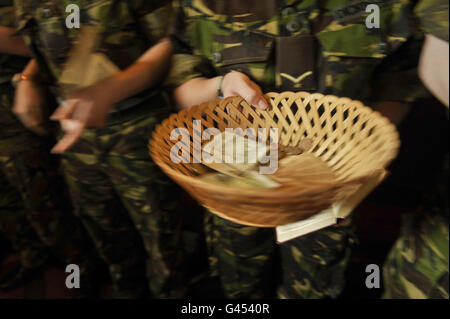 Une collecte d'argent de l'église est transmise après un service d'action de grâce à l'église Saint-Jean-Baptiste, Colerne, Wiltshire, où des soldats de la troupe Alpha, 244, Escadron de transmissions, 21, Régiment de transmissions (appui aérien) basé à Colerne, Sont présents avant de recevoir leurs médailles opérationnelles de l'Afghanistan après leur retour d'un déploiement réussi de six mois à l'appui de la Force d'hélicoptères interarmées (Afghanistan). Banque D'Images