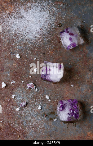 Des cubes de glace avec des fleurs lilas, le sucre blanc et fleurs lilas sucrées de vieux fer rouillé. Vue d'en haut Banque D'Images