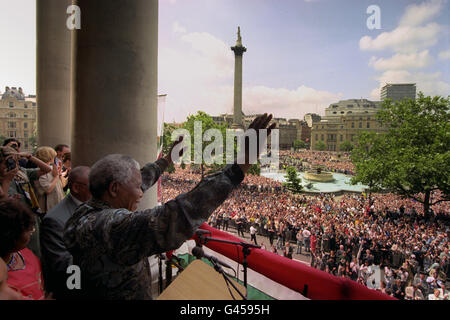 Le président sud-africain Nelson Mandela reconnaît les encouragements de la vaste foule de Trafalgar Square depuis le balcon de South Africa House. Sous le regard de la colonne de Nelson, le Président s'est adressé aux foules lors de la dernière étape de sa visite d'État de quatre jours en Grande-Bretagne. Voir la visite DE l'histoire de l'Assemblée parlementaire MANDELA. Photo de Tony Harris/PA. Banque D'Images