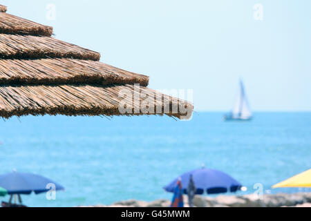 Plage avec parasols réalisés avec le bambou et la paille dans le luxueux resort Banque D'Images