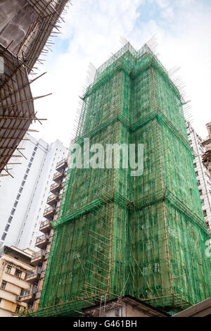 Les échafaudages en bambou traditionnel entoure un bâtiment en construction à Hong Kong, Chine. Banque D'Images