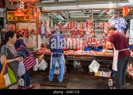 Hong Kong, Chine - le 30 mars 2015 : les bouchers découper le porc en vente sur gage Street dans le quartier central du centre-ville de Hong Kong. Banque D'Images