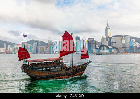 Le rendu HDR d'un bateau jonque Chinoise typique avec voiles rouge sur le port de Victoria à Tsim Sha Tsui, Hong Kong. La couleur émeraude Banque D'Images