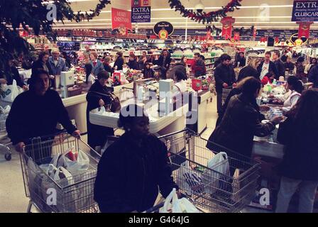 Les clients profitent de vingt-quatre heures de shopping au supermarché Tesco de Brent Cross, qui fait la queue pendant les premières heures de ce matin. Tesco, Safeways, ASDA et d'autres magasins de Londres ont gardé leurs portes ouvertes toute la nuit. *..pour permettre aux clients de terminer leurs achats de Noël à leur guise, menant à la spéculation qu'ils pourraient prolonger leurs heures tout au long de l'année. Banque D'Images