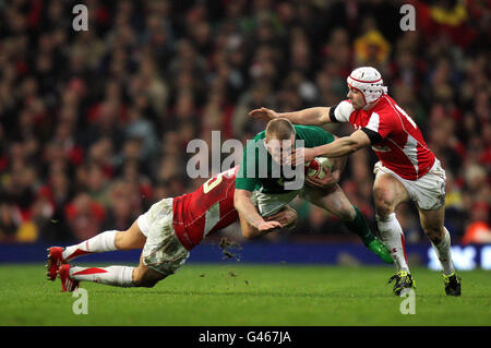 Le Keith Earls d'Irlande est attaqué par Lee Byrne et Leigh Halfpenny du pays de Galles lors du match des RBS 6 Nations au Millennium Stadium de Cardiff. Banque D'Images