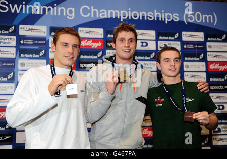 David Davies (au centre) de la ville de Cardiff, Daniel Fogg (à gauche) de Loughborough Universty et Tom Allen, de Swansea Performance, célèbrent la victoire de l'or, de l'argent et du Bronaze lors de la finale Freestyle masculine du 1500 m Open lors des championnats britanniques de natation au gaz au centre aquatique de Manchester. Banque D'Images