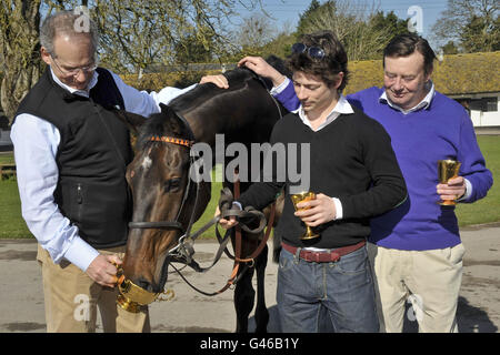 L'entraîneur Nicky Henderson (à droite) avec le propriétaire Robert Waley-Cohen et le jockey Sam Waley-Cohen (au centre) comme long Run est accueilli à la maison, Seven Barrows, Lambourn. Banque D'Images