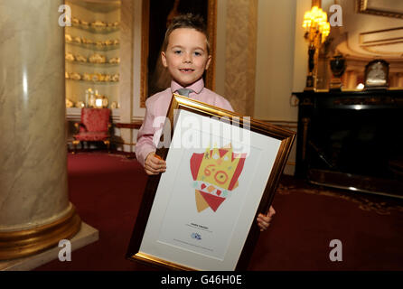 Haris Vincent, de Norwich, âgé de sept ans, attend de montrer à la Reine son dessin gagnant pour la catégorie des 6-8 ans, d'un emblème pour le Jubilé de diamant de la Reine, dans un concours organisé par BBC TV Blue Peter programme pour le Jubilé l'année prochaine, à Buckingham Palace dans le centre de Londres. Banque D'Images