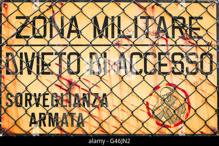 Panneau jaune qui lit dans la zone "Militaire italienne, pas d'entrée, de surveillance armés". Banque D'Images