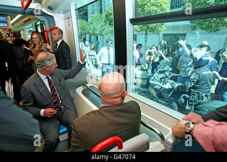 Le prince de Galles se démène vers la foule en prenant un tramway avec la duchesse de Cornouailles lors d'une visite à Séville en Espagne. Banque D'Images