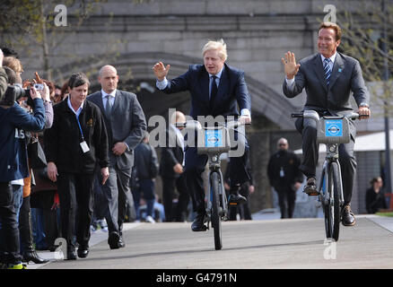 Le maire de Londres Boris Johnson prend l'ancien gouverneur de Californie Arnold Schwarzenegger (à droite) pour une promenade sur l'un de ses « vélos Boris » lors de sa visite à l'hôtel de ville de Londres. Banque D'Images