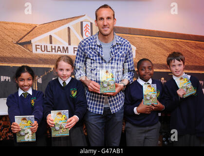 Mark Schwarzer de Fulham avec des enfants lisant des copies de son livre Banque D'Images