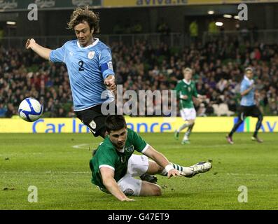 Shane long (à droite), de la République d'Irlande, descend après avoir lutté pour le bal avec Diego Lugano (à gauche), de l'Uruguay. Banque D'Images