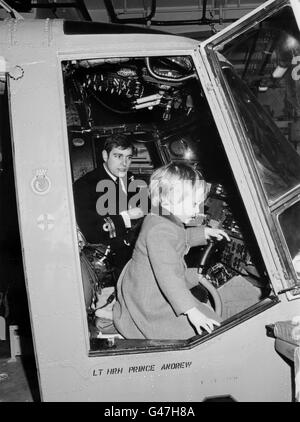 Le prince Andrew garde un œil vigilant sur son neveu de trois ans, le prince William, aux commandes de l'hélicoptère du prince à bord du HMS Brazen. Banque D'Images