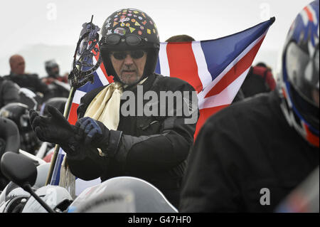 Un motard pose ses gants alors que les motards se rassemblent à l'aérodrome de Hullavington en préparation pour la course caritative Ride of respect à travers la ville de Wootton Bassett dans le Wiltshire en aide aux héros afghans. Banque D'Images