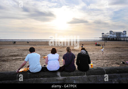 Les gens aiment les frites en s'imprégnant du coucher du soleil sur le Grand Pier à Weston-Super-Mare après une autre journée chaude à travers le pays. Banque D'Images