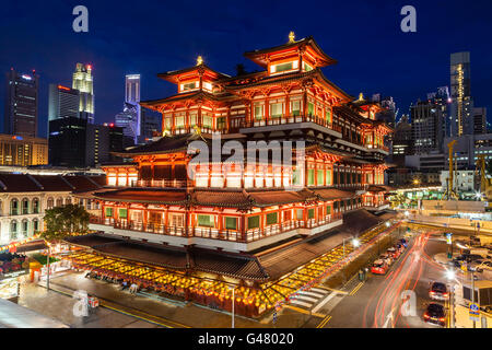 Vue de la nuit de l'Buddha Tooth Relic Temple dans le quartier chinois de Singapour, avec des toits de la ville en arrière-plan. Banque D'Images