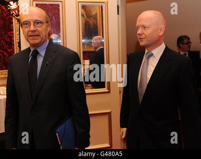 Le ministre britannique des Affaires étrangères William Hague (à droite) rencontre le ministre français des Affaires étrangères Alain Juppe au début de la conférence en Libye à Londres. Banque D'Images