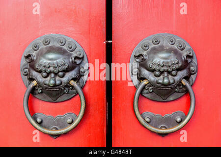 Chinois traditionnel portes avec poignées en laiton symbolique de la tête de lion. C'est croire pour écarter le mal et instaurer la bonne chance pour Banque D'Images