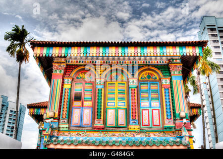 Le rendu HDR d'une façade de bâtiment coloré dans Little India, Singapour, avec de grandes tours d'habitation à l'arrière-plan. Banque D'Images