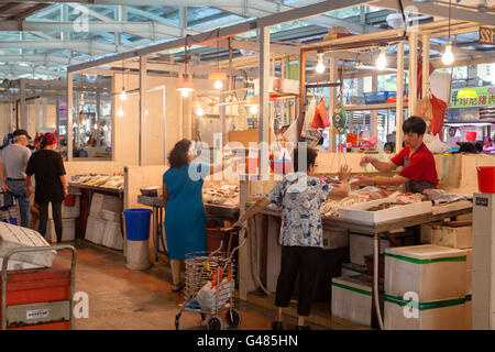 Singapour, Singapour - le 11 décembre 2014 : un poissonnier dans un marché traditionnel à Singapour à aider un client. Pour les résidents locaux Banque D'Images