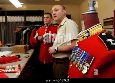 Maître senior sur mesure Steve Shield (à droite) avec Martin Hughes des ColdSteam Guards, dans la cabine d'essayage en vue du mariage royal du Prince William et de Kate Middleton, à Wellington Barracks, Londres. Banque D'Images