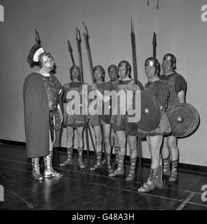 Le sergent-major de l'ex-régimentaire Ronald Brittain, à gauche, met un parti de recrues 'romaine' par leurs mouvements d'exercices à l'école Bedford, Holborn Boys Club, Londres. Brittain utilise sa voix forte pour former 32 anciens guardsmen qui apparaîtront dans l'uniforme des centurions romains lors de la première caritative du film 'Spartacus'. Banque D'Images