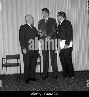 Dennis Concannon, à droite, le député travailliste de Mansfield, avec David Riley de Nottingham, après avoir été mesuré par l'ancien sergent-major régimentaire Ronald Brittain, à gauche, à l'hôtel Londoner, à Londres, pendant le plus haut Man in Town Competition. Banque D'Images