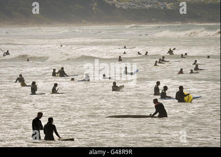 Les surfeurs, les bodyboardeurs et les nageurs apprécient les vagues de la plage de Woolacombe, dans le nord du Devon, lors d'une journée chaude. Banque D'Images