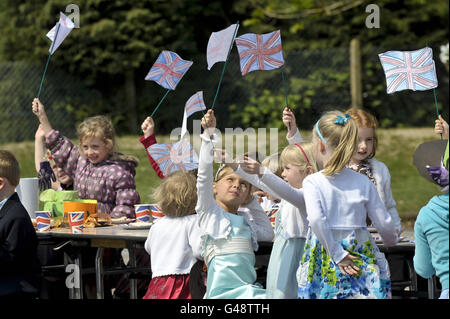 Les enfants volent leurs drapeaux Union faits à la main à l'école primaire Bucklebury Church of England Primary School Royal mariage Party dans le terrain de jeu de l'école. Banque D'Images