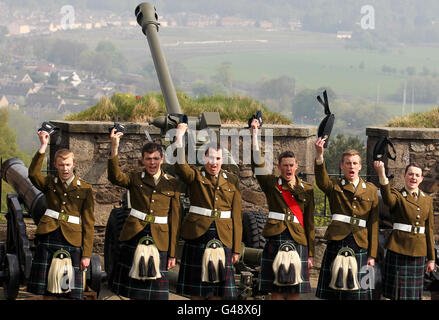Cadets officiers des universités Glasgow et Strathclyde corps d'instruction des officiers et Gunners de 212 batterie, 105 Régiment Royal Artillery (bénévoles) élèvent leurs chapeaux et applaudissent après avoir tiré un 21-pistolet saluant pour marquer le 85e anniversaire de la reine au château de Stirling. Banque D'Images