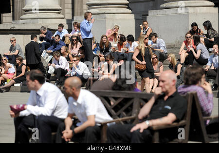 Les employés de la ville apprécient le soleil du déjeuner à l'extérieur de la Bank of England, Londres, tandis que les amateurs de soleil ont profité du jour le plus chaud de l'année jusqu'à présent - et le temps anormalement chaud est prévu pour se poursuivre le week-end de Pâques. Banque D'Images