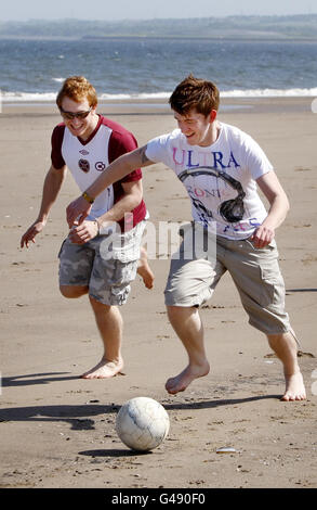 Les membres du public jouent au football sur Portobello Beach, près d'Édimbourg, en Écosse, tandis que le temps chaud continue à travers le Royaume-Uni. Banque D'Images