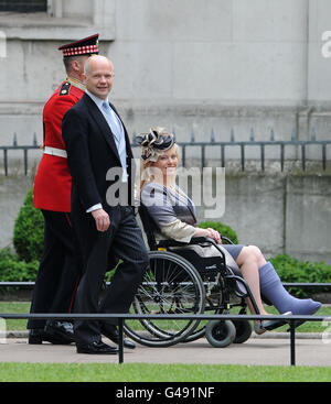 Le secrétaire aux Affaires étrangères William Hague et son épouse Ffion Hague, qui porte une veste gris clair assortie à son plâtre gris, arrivent à l'abbaye de Westminster avant le mariage entre le prince William et Kate Middleton. Banque D'Images