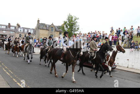 Les chevaux et leurs cavaliers traversent les rues de Hawick lors de la première sortie de la Hawick Common-Riding. Le Cornet et ses partisans se rendent sur leurs sorties, qui les voient visiter les villages et les fermes environnants. Cependant, le trajet principal - habituellement deux semaines avant le week-end de Common-Riding - est le trajet de vingt-quatre miles jusqu'à Mosspaul et retour. Banque D'Images