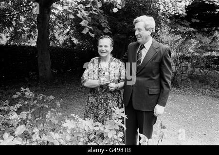 Le Dr Garret FitzGerald, chef du principal parti de l'opposition, Fine Gael, se déplace dans les jardins de son domicile de Dublin avec sa femme Joan, en attendant les résultats de l'élection irlandaise. Banque D'Images