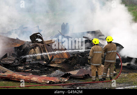 Des pompiers travaillent sur les lieux d'un incendie dans un hangar de chemin de fer à côté de la ligne ferroviaire principale d'Édimbourg à Glasgow à Bonnybridge, près de Cumbernauld. Banque D'Images