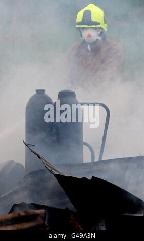 Des pompiers travaillent sur les lieux d'un incendie dans un hangar de chemin de fer à côté de la ligne ferroviaire principale d'Édimbourg à Glasgow à Bonnybridge, près de Cumbernauld. Banque D'Images