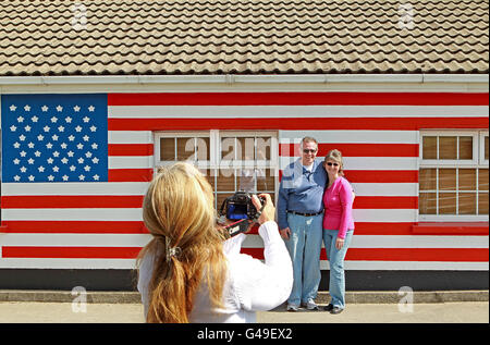 Catriona Morrison, originaire de Pensylvanie, prend une photo des touristes américains Darrell Sheeley et de son épouse Marsh devant un bungalow peint avec le drapeau américain dans Moneygall, Co Offaly, Alors que la fièvre d'Obama balaie le village avec des locaux réparant des trottoirs et peignant des maisons avant l'arrivée du président Barack Obama plus tard ce mois-ci. Banque D'Images