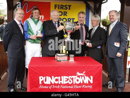 Jockey Jamie Codd (2e à gauche) célèbre avec le trophée et son équipe après avoir remporté le KFM Hunters Chase pour la coupe Bishopscourt sur la presse à balles Banque D'Images