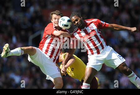 Salif Diao (à droite) et Danny Pugh (à gauche) de la ville de Stoke Les uns les autres pour la même balle ainsi que pour Arsenal's. Robin van Persie Banque D'Images