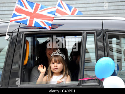 Une jeune fille habillée comme princesse voyage dans un taxi sur le Mall à Londres à la veille du mariage royal. Banque D'Images