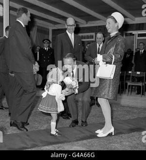 La princesse de la Couronne Sonja de Norvège rit en doutant Ann-Christn Wiggen, 3 ans, d'Oslo, a refusé de renoncer à la postiche des fleurs parce qu'elle ne croyait pas « la dame était vraiment une princesse ». Un fonctionnaire souriant a essayé de les amadouer d'elle lors de l'ouverture officielle d'un centre sportif norvégien de marins à Londres. Banque D'Images