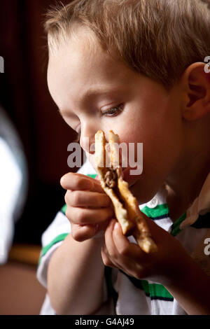 3 ans Emerson Bennett mange un hamburger chez Louis' Lunch à New Haven, CT, USA, 26 mai 2009. Banque D'Images