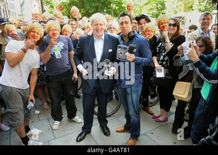 Le maire de Londres Boris Johnson (au centre à gauche) remet des radios numériques au disc jockey Christian O'Connell (au centre à droite) lors d'une promotion à Absolute radio, Londres. Banque D'Images