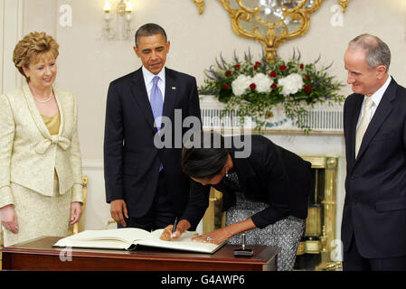 LE président AMÉRICAIN Barack Obama, (deuxième à gauche) regarde sa femme, la première dame Michelle Obama, signer le livre des visiteurs, regardé par le président irlandais Mary McAleese (à gauche) et son mari, le Dr Martin McAleese, à Aras an Uachtarain, lors de la visite du président Obama en Irlande. Banque D'Images